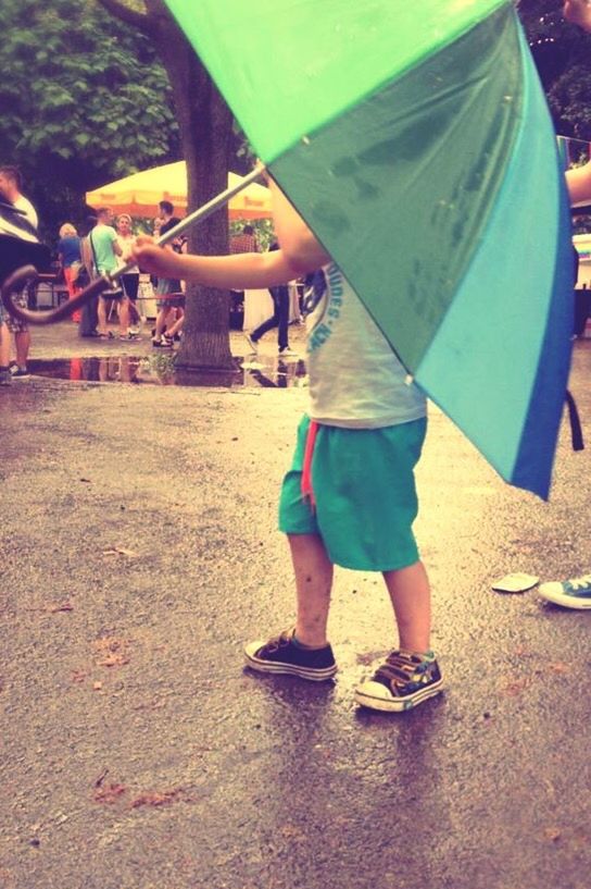 lifestyles, leisure activity, low section, full length, childhood, casual clothing, person, umbrella, sunlight, standing, day, outdoors, shoe, park - man made space, shadow, street, high angle view