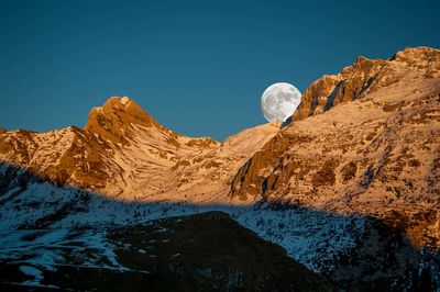 Scenic view of snowcapped mountains against clear blue sky