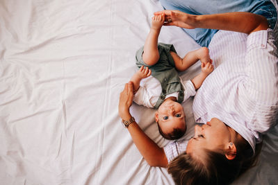 High angle view of mother and daughter on bed at home