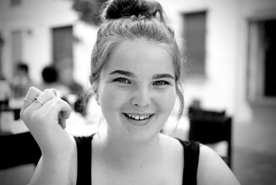 Portrait of a smiling young woman holding outdoors