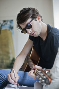 Young musician writing songs on an acoustic guitar