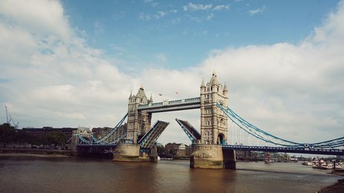 View of suspension bridge against cloudy sky