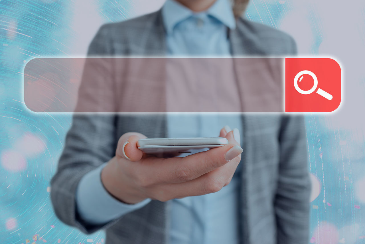 MIDSECTION OF MAN HOLDING MOBILE PHONE IN OFFICE