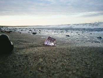 Diamond on beach against cloudy sky