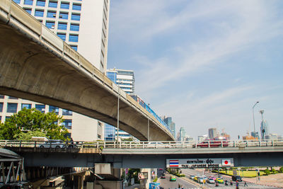 Bridge over river in city against sky