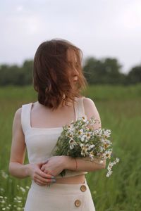 Beautiful woman holding a bouquet of daisies flowers