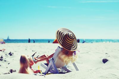 Dolls at beach against sky