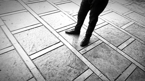 Low section of man standing on tiled floor