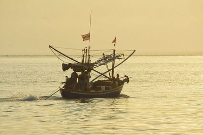 Fishing boat in sea against clear sky