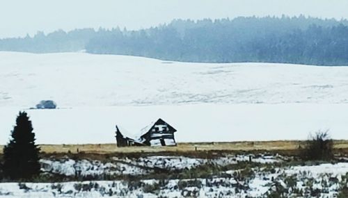 Built structure on snow field against sky