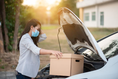Woman holding smart phone in car
