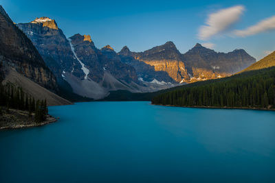 Scenic view of lake and mountains against blue sky