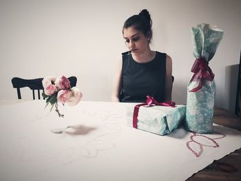 Young woman sitting on table at home