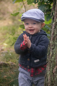 Portrait of cute baby boy wearing cap standing outdoors