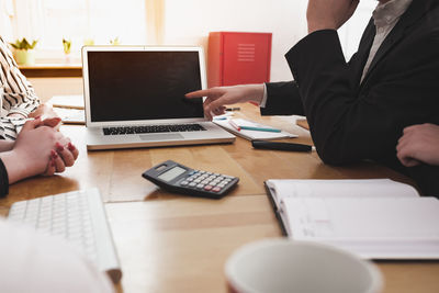 Midsection of man using laptop on table