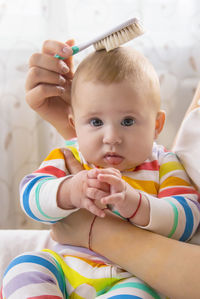 Portrait of cute baby girl sitting with mother