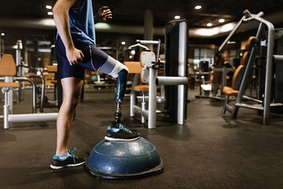 Low section of man with prosthetic leg exercising in gym