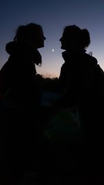 Silhouette couple against sky at night