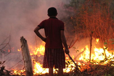 Rear view of man standing against bonfire