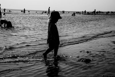 Silhouette woman on beach against sky