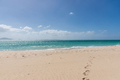 Scenic view of beach against blue sky