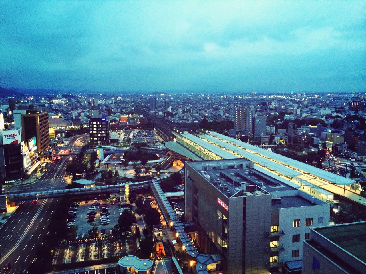 cityscape, city, building exterior, architecture, built structure, high angle view, crowded, sky, illuminated, residential district, city life, cloud - sky, residential building, residential structure, dusk, night, cloud, road, outdoors, aerial view