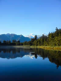 Scenic view of lake against clear blue sky