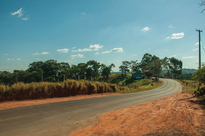 Countryside paved road on hilly landscape covered by meadows and trees, near pardinho, brazil.