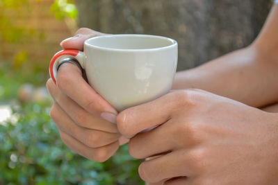 Close-up of hand holding coffee cup