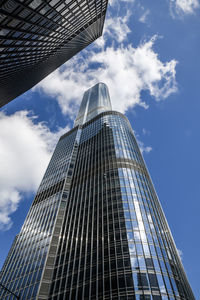 Low angle view of modern glass building against sky