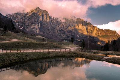 Scenic view of lake by mountains against sky