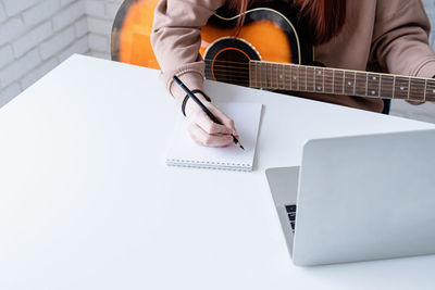 Midsection of man playing guitar