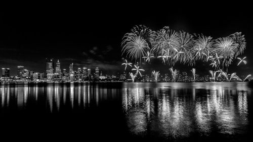 Firework display over river at night