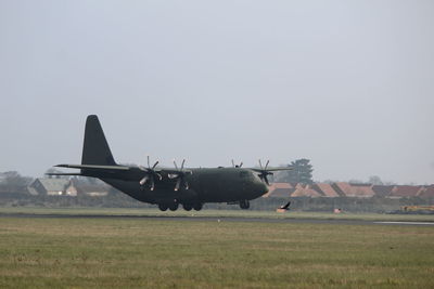 Airplane on airport runway against sky