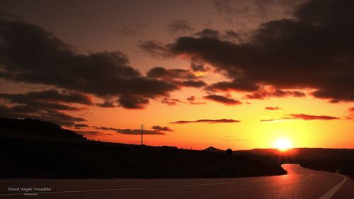 Silhouette landscape against orange sky