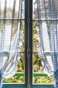 Close-up of closed window with white and blue shades