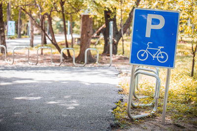 Road sign by trees in city