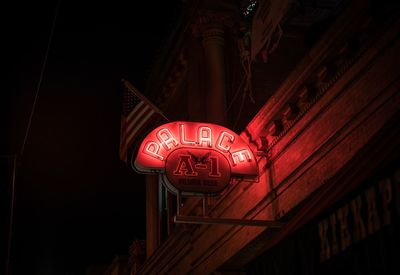 Low angle view of illuminated text on building at night