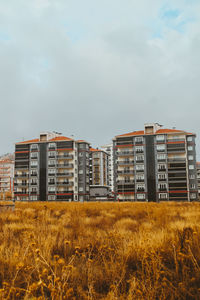 Buildings on field against sky