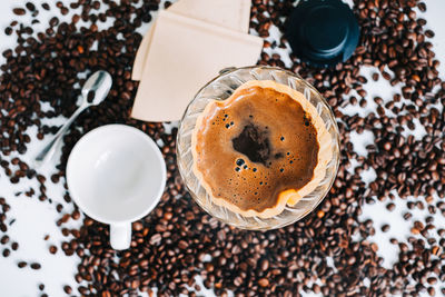 Fresh brewed coffee in a cup using alternative method, with pour over dripper and paper filter.