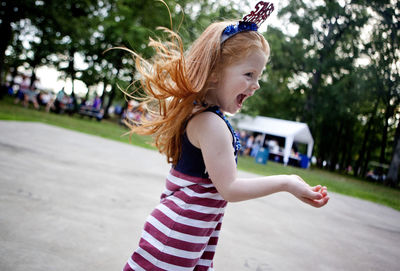 Side view of happy girl dancing at fourth of july event