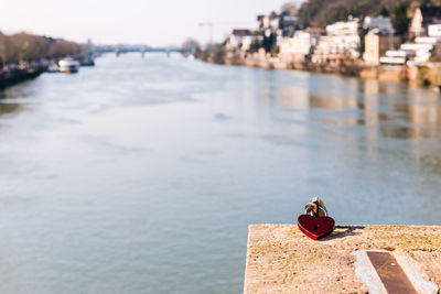 Heart shape padlock at riverbank in city