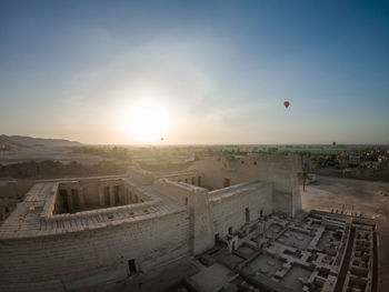 Aerial view of city buildings against sky during sunset