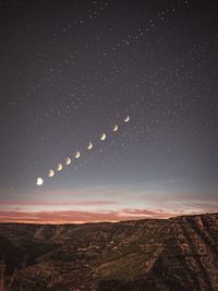 Scenic view of landscape against star field at night