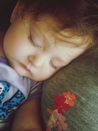 Close-up of cute baby girl on bed