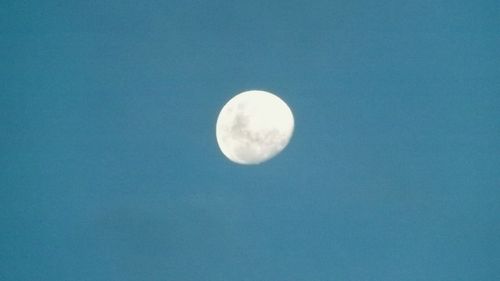 Low angle view of moon against blue sky