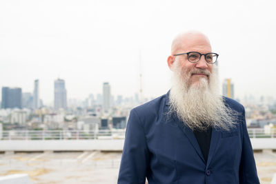 Portrait of man standing against cityscape