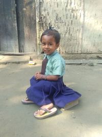 Portrait of smiling girl sitting on floor