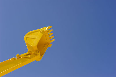 Shovel of excavator on clear sky