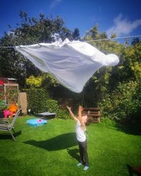 Rear view of woman standing on field against sky